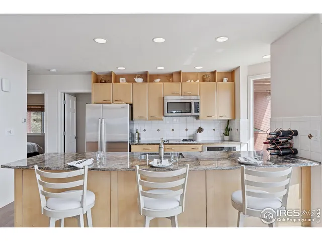 a kitchen with kitchen island granite countertop a sink and cabinets