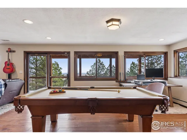 a living room with furniture pool table and a large window