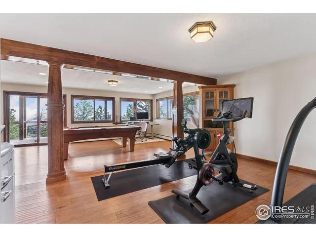 a living room with furniture gym equipment and large windows