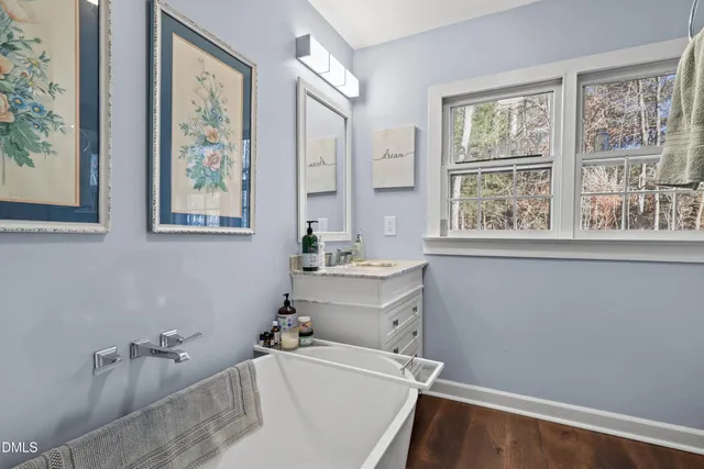 a front view of a house with a yard covered with snow and trees