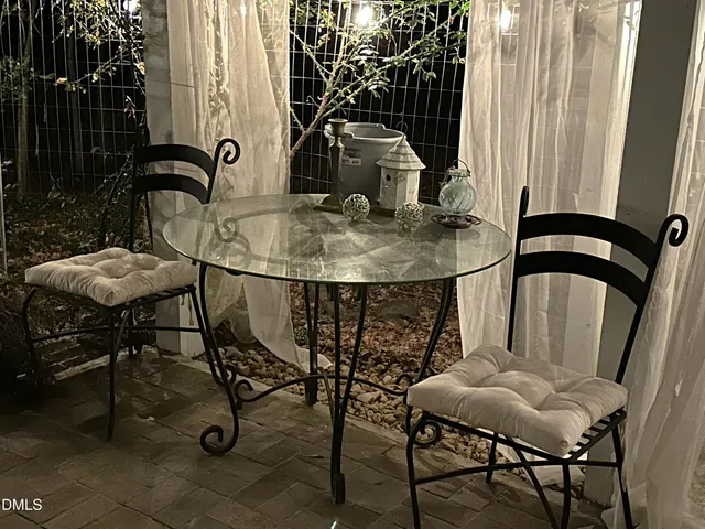 a view of patio with a table and chairs under an umbrella