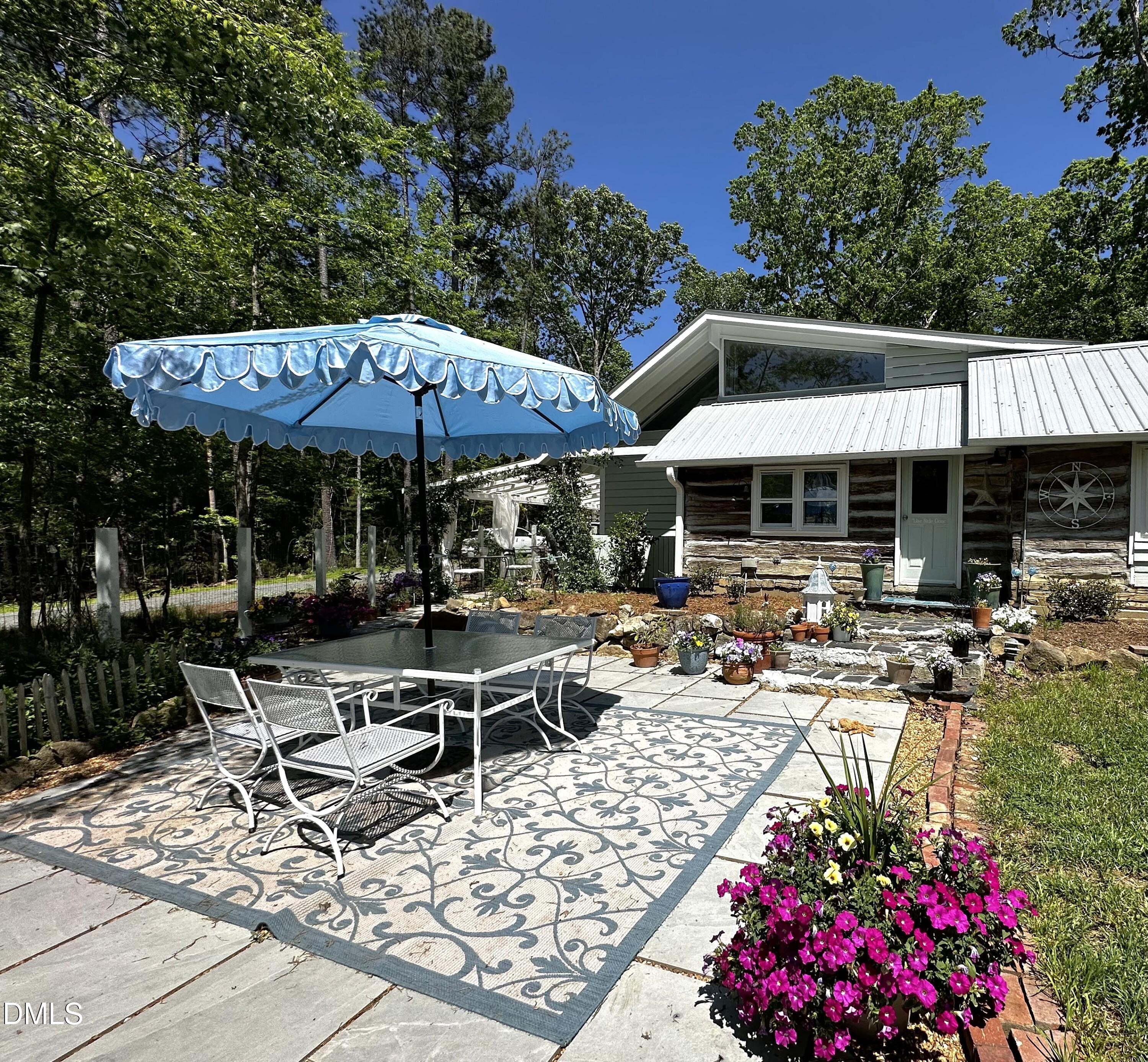 6202 Montgomery Ests Road Hillsborough, NC 27278 - Photo 5 of 91 a view of a patio with table and chairs under an umbrella with a barbeque