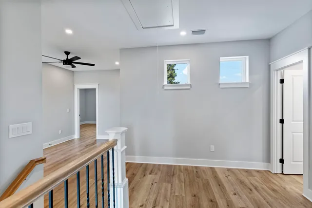 a view of a hallway with wooden floor and a chandelier