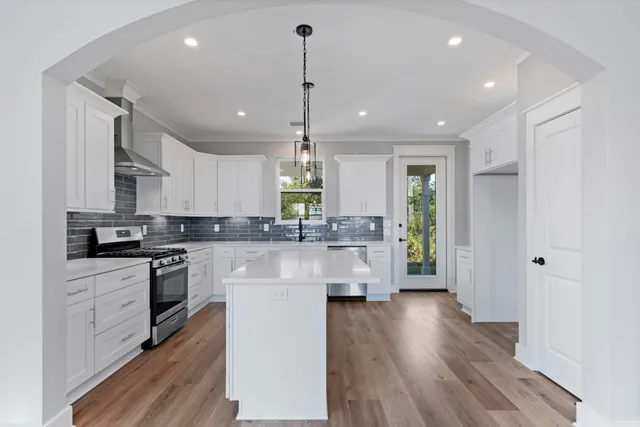 a kitchen with kitchen island a counter top space a sink stainless steel appliances and cabinets
