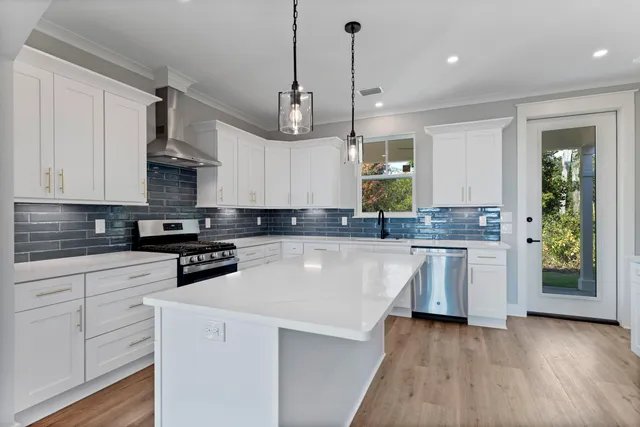a large kitchen with granite countertop a white cabinets and a wooden floor
