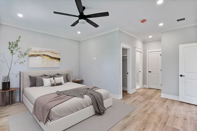 a bedroom with a large bed and a chandelier