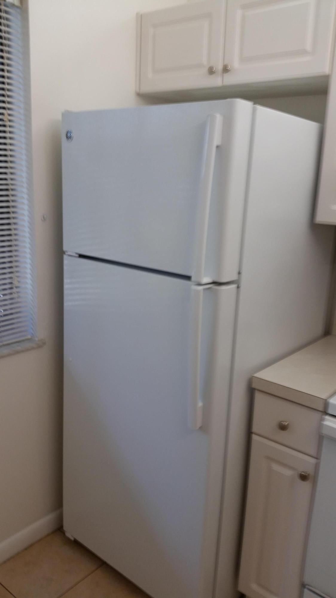 800 Northwest Fork Road, Unit 71 Stuart, FL 34994 - Photo 14 of 23 a white refrigerator freezer and a dishwasher with wooden floor