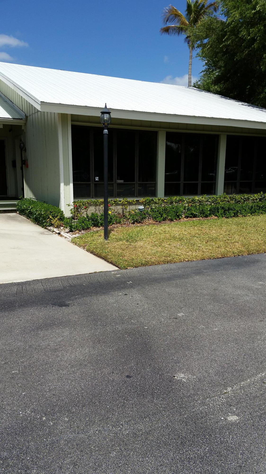 800 Northwest Fork Road, Unit 71 Stuart, FL 34994 - Photo 9 of 23 a front view of a house with a yard and garage