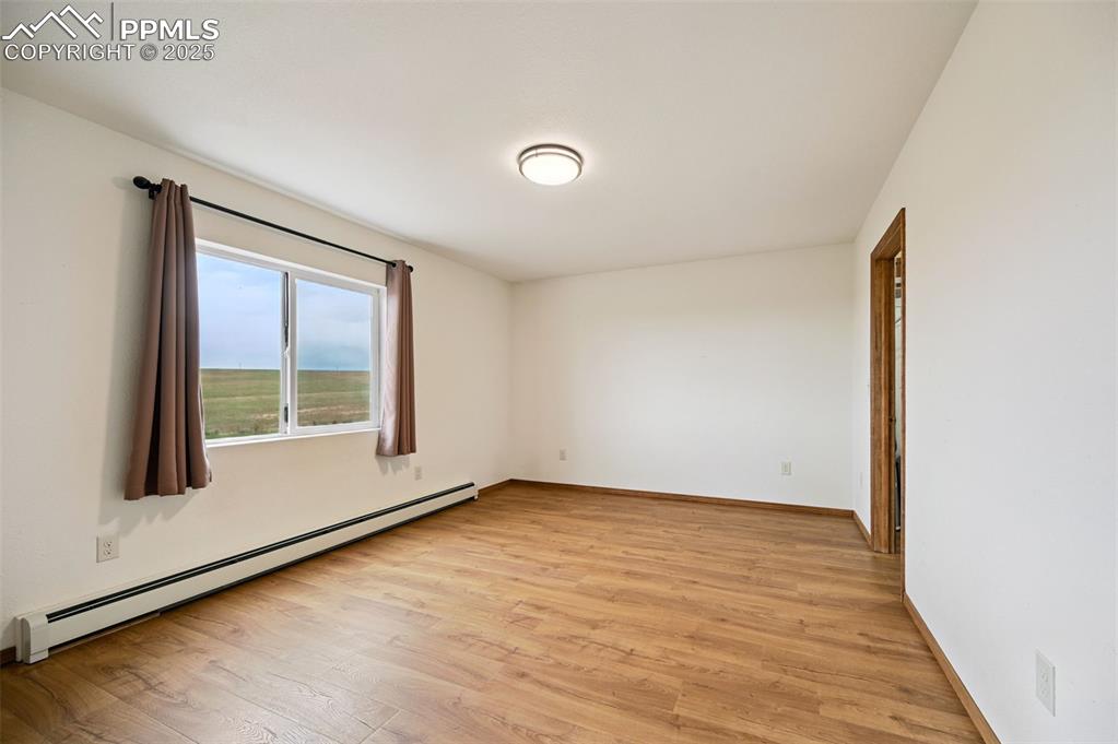 1220 Choate Lane Yoder, CO 80864 - Photo 17 of 47 a view of an empty room with wooden floor and a window