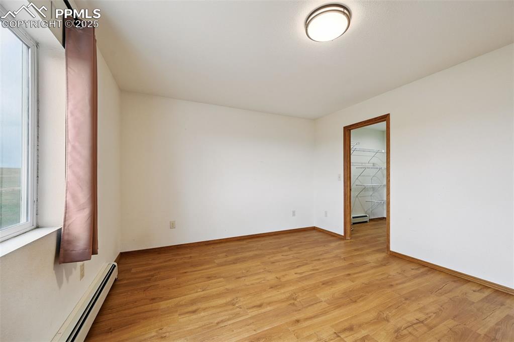 1220 Choate Lane Yoder, CO 80864 - Photo 18 of 47 an empty room with wooden floor and windows