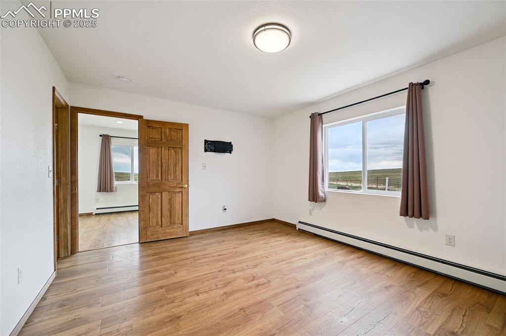 1220 Choate Lane Yoder, CO 80864 - Photo 19 of 47 an empty room with wooden floor and windows