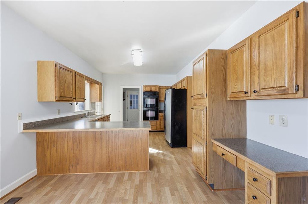 2453 Basin Court Gainesville, GA 30506 - Photo 12 of 47 a large kitchen with stainless steel appliances wooden floors and large window