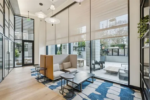 a living room with furniture large window and wooden floor
