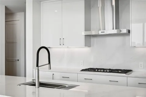 a kitchen with white cabinets and appliances