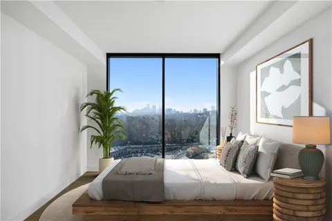 a bedroom with a large bed and a potted plant