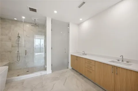 a large bathroom with a shower and a sink