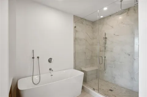 a bathroom with a white bath tub a shower and sink