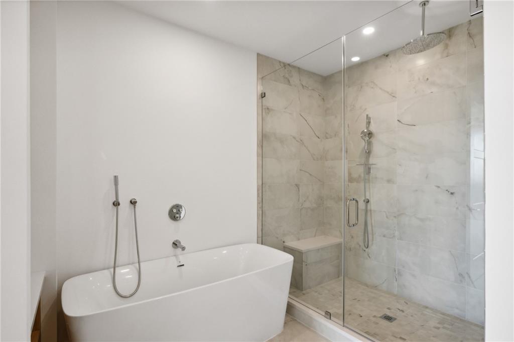 2425 Peachtree Street Northeast, Unit 1106 Atlanta, GA 30305 - Photo 9 of 43 a bathroom with a white bath tub a shower and sink