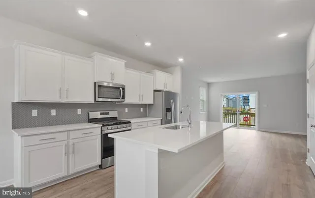 a kitchen with white cabinets and appliances