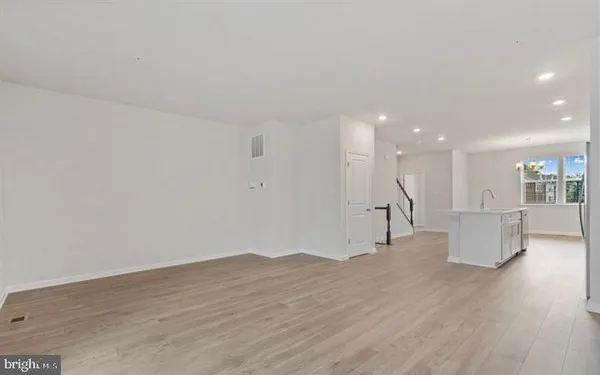 a view of a big room with wooden floor and a window
