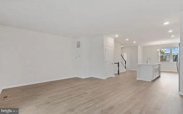a view of a big room with wooden floor and a window