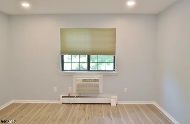 a view of a room with wooden floor and a window