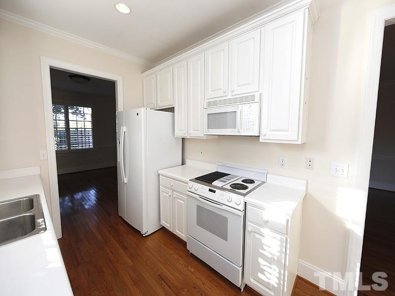 2301 Elmsford Way Raleigh, NC 27608 - Photo 14 of 25 a kitchen with white cabinets and white appliances