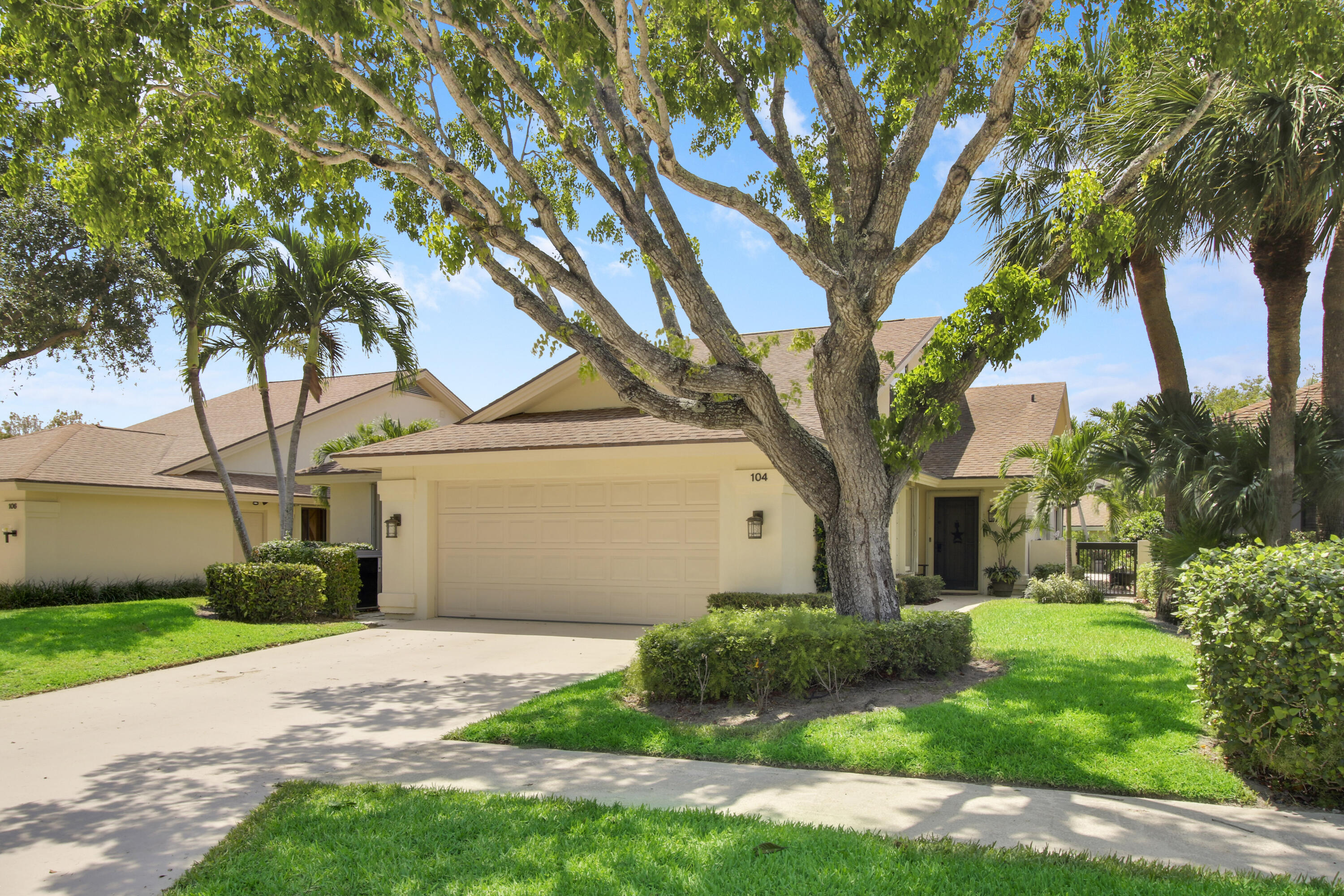 104 Harbourside Circle Jupiter, FL 33477 - Photo 1 of 41 a front view of a house with a yard and an trees