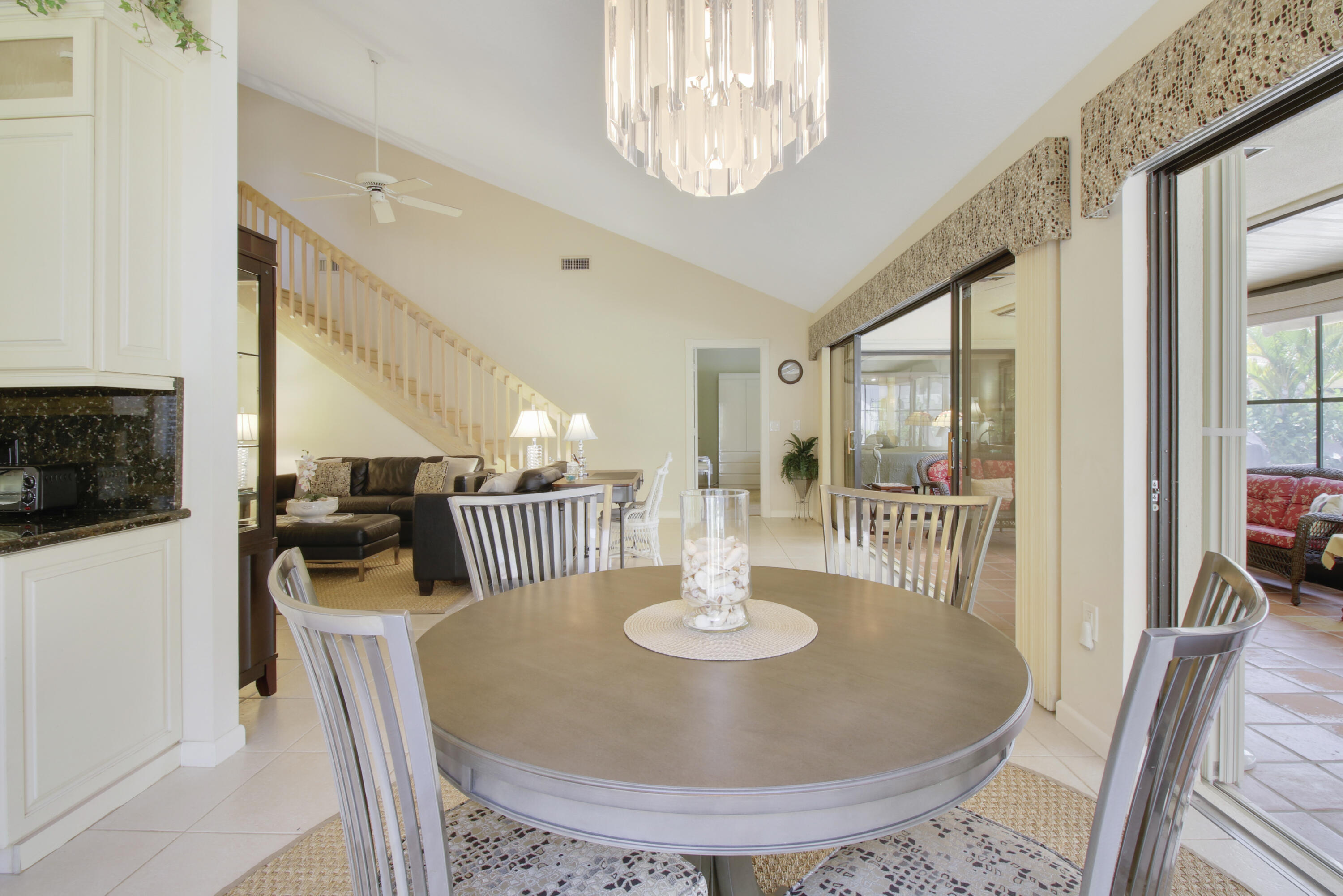 104 Harbourside Circle Jupiter, FL 33477 - Photo 12 of 41 a dining room with furniture a chandelier and wooden floor