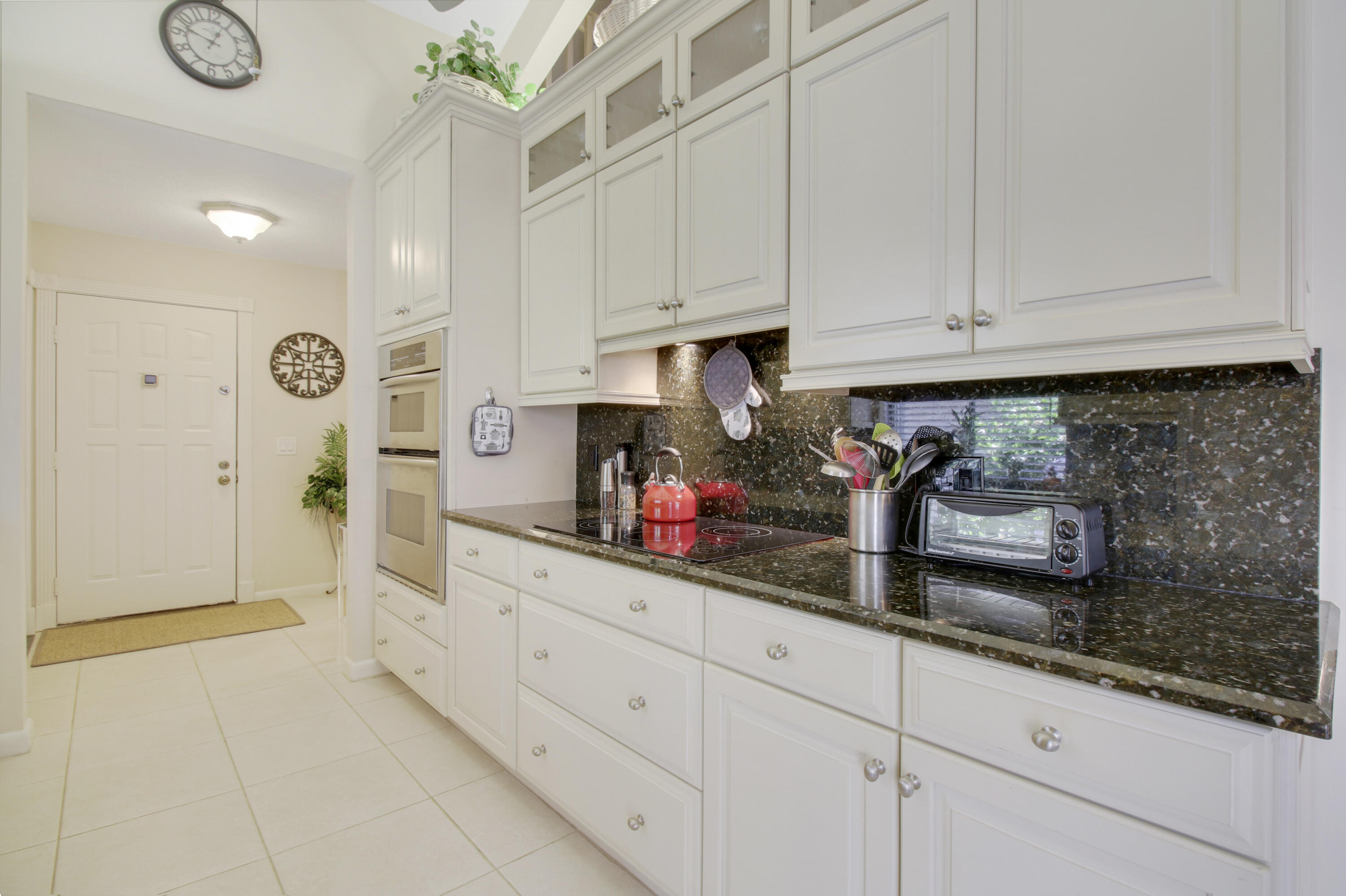 104 Harbourside Circle Jupiter, FL 33477 - Photo 10 of 41 a kitchen with white cabinets and appliances