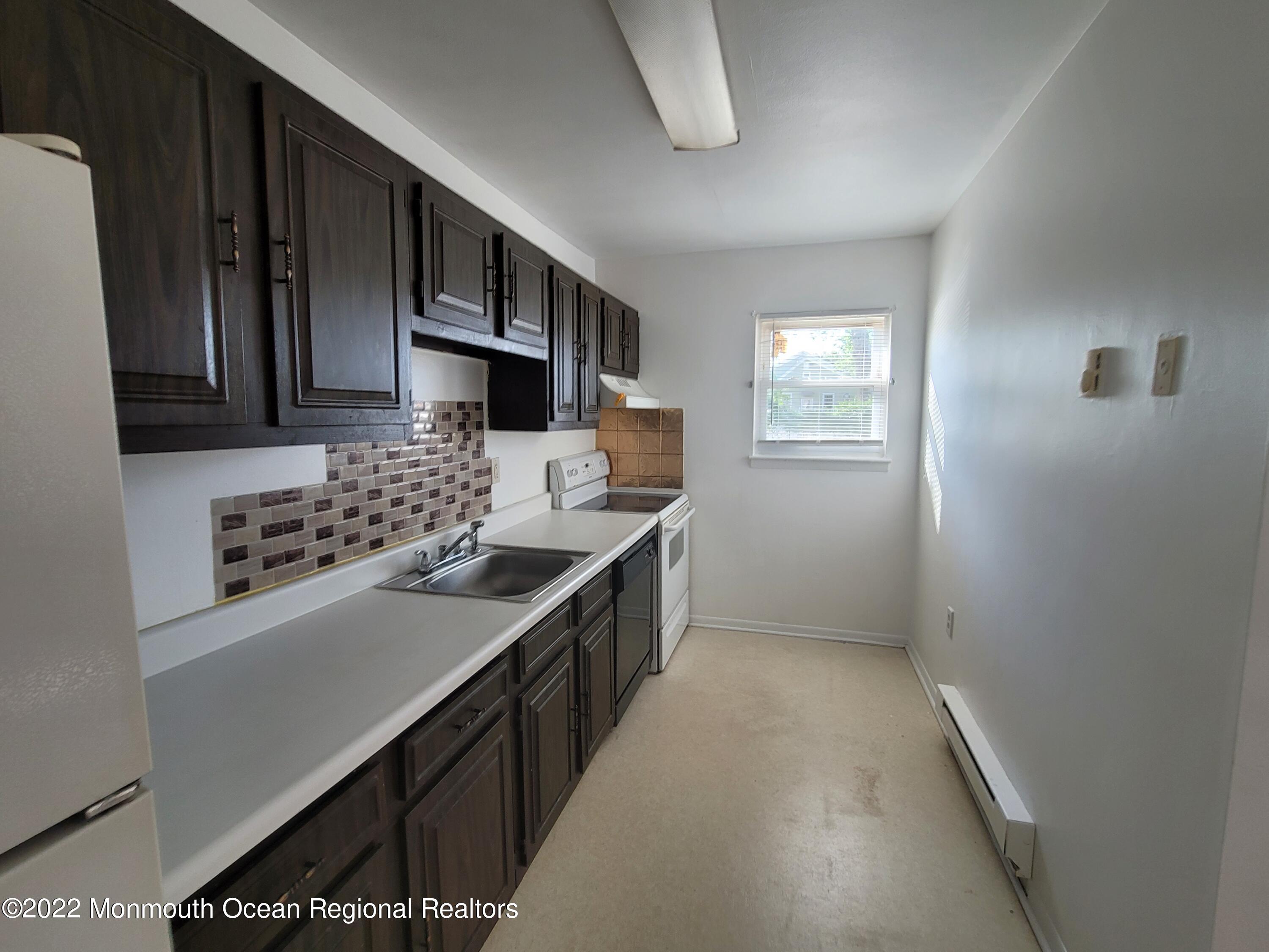 55 White Street, Unit C Eatontown, NJ 07724 - Photo 6 of 21 a kitchen with a sink stove top oven and cabinets