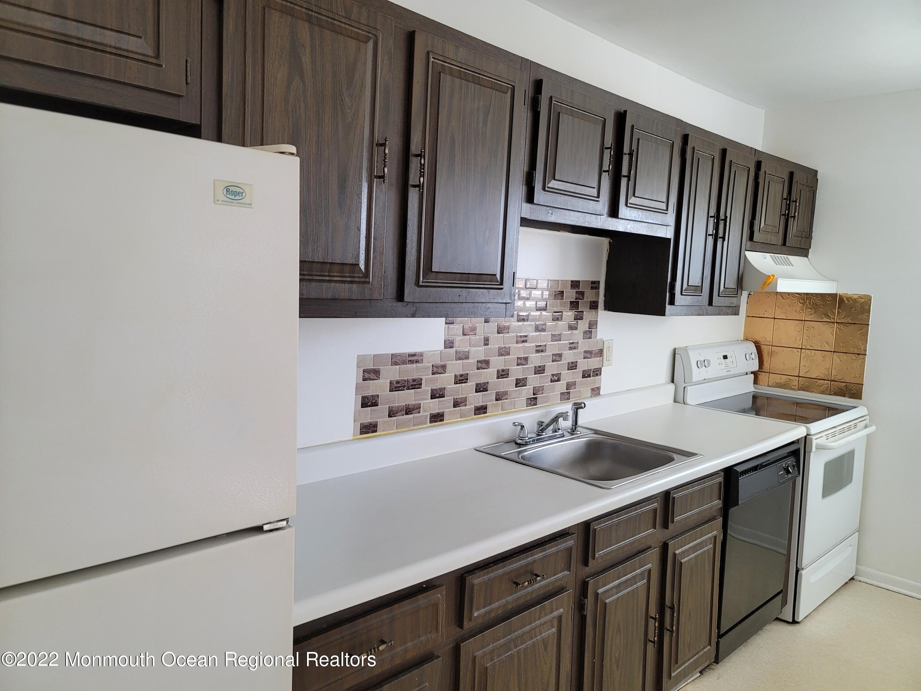 55 White Street, Unit C Eatontown, NJ 07724 - Photo 7 of 21 a kitchen with stainless steel appliances a sink a stove a microwave a refrigerator and cabinets