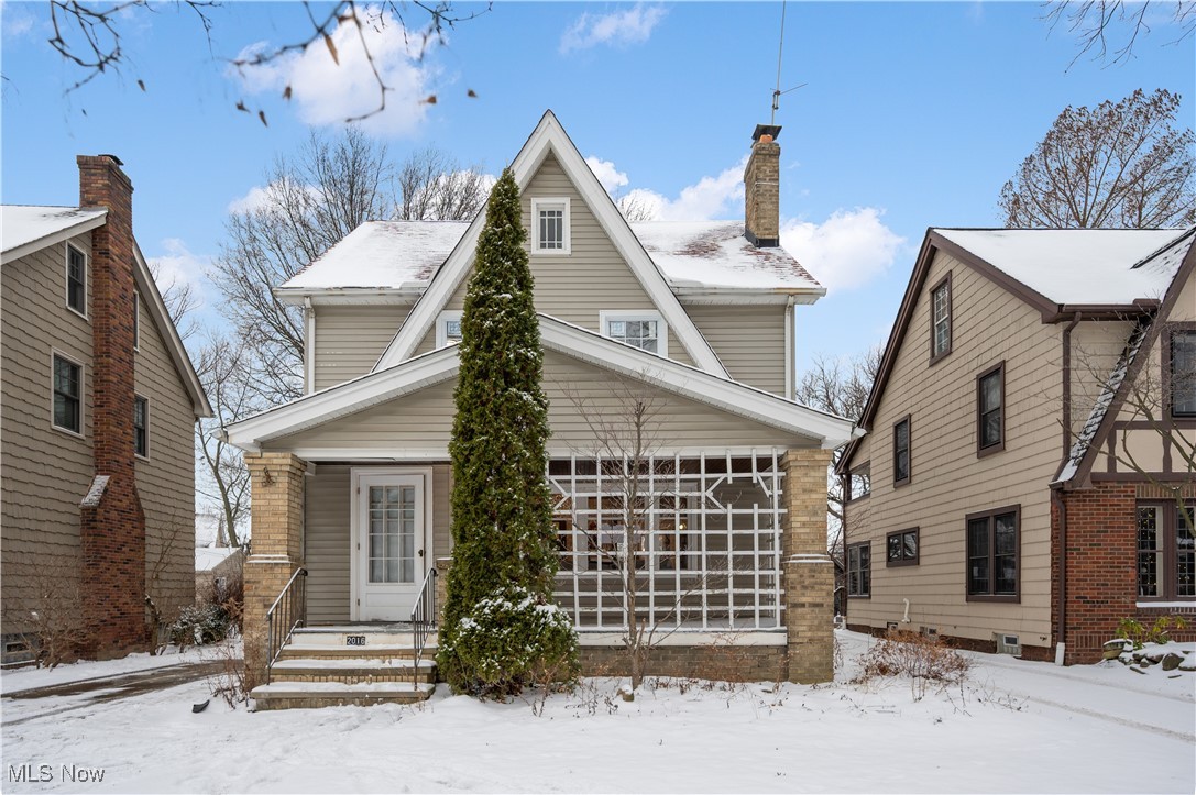 View of front of house with a chimney and a porch