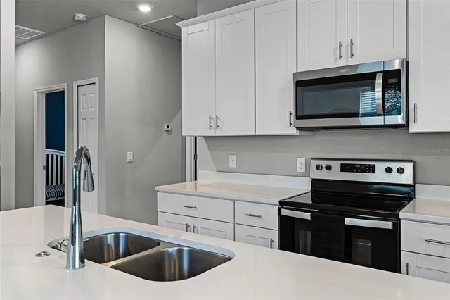 a kitchen with granite countertop a sink and a stove top oven