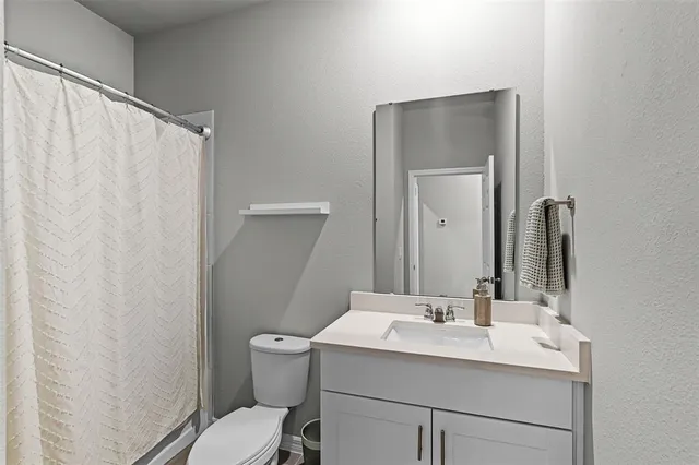 a bathroom with a sink vanity mirror and toilet