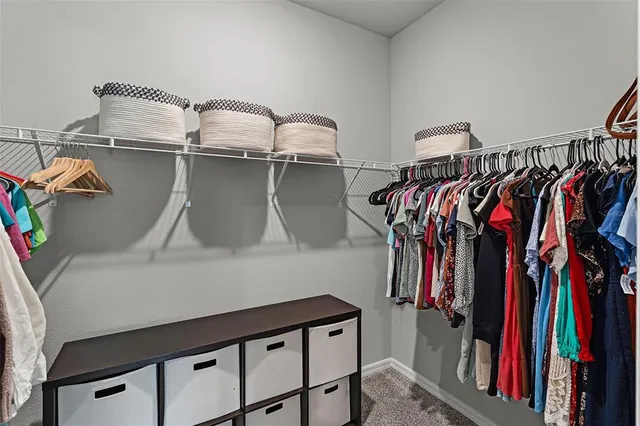 a view of walk in closet with clothes and shoes