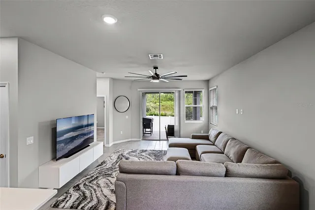 a living room with furniture a fireplace and a large window