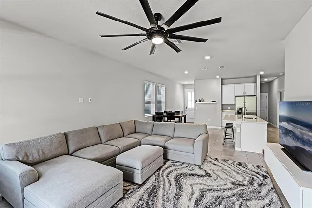 a living room with furniture ceiling fan and a rug