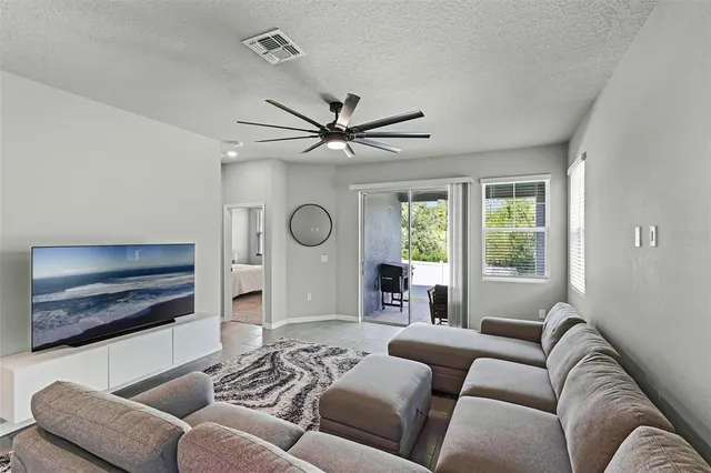 a living room with furniture a window and a flat screen tv