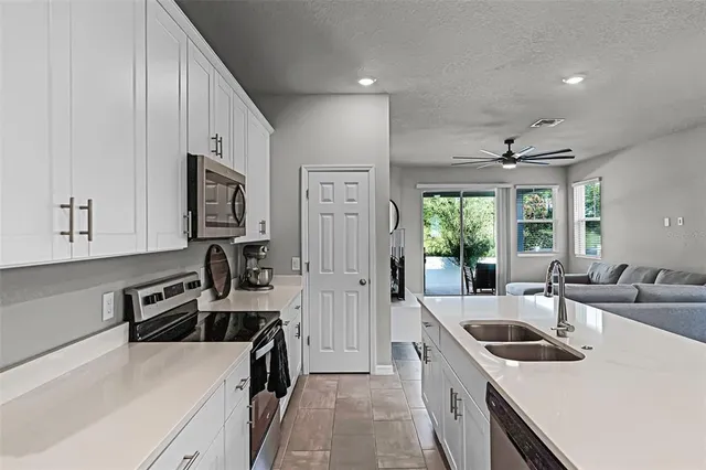 a kitchen that has a sink a stove and a refrigerator