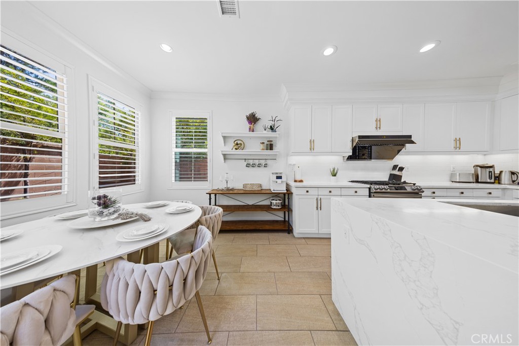 55 Rembrandt Irvine, CA 92620 - Photo 11 of 29 a kitchen with a stove a sink a kitchen island and chairs
