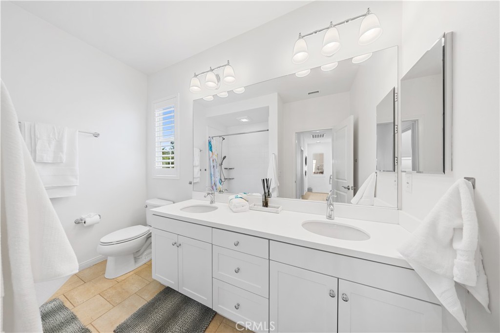 55 Rembrandt Irvine, CA 92620 - Photo 19 of 29 a bathroom with a double vanity sink toilet and a mirror