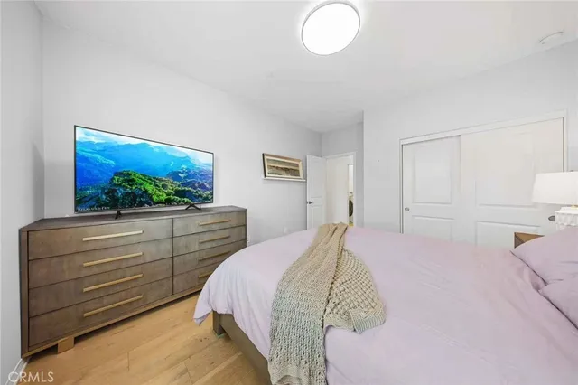 a spacious bedroom with a bed and wooden floor