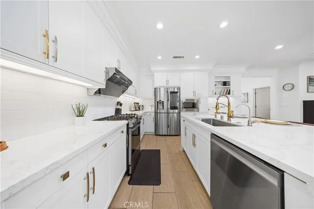 a large kitchen with stainless steel appliances kitchen island a large counter top a stove and a sink