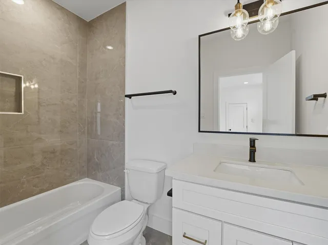 a bathroom with a toilet a sink a mirror and shower