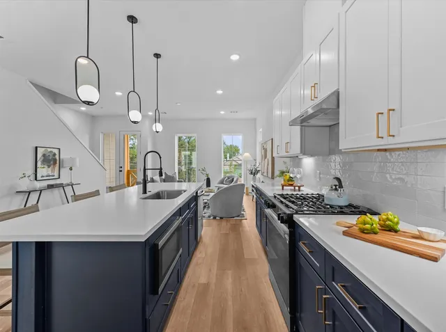 a kitchen with a sink a counter space a stove and cabinets