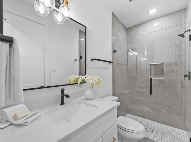 a bathroom with a sink a toilet and shower