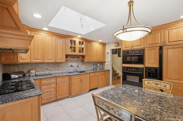a kitchen with stainless steel appliances granite countertop a stove refrigerator and cabinets