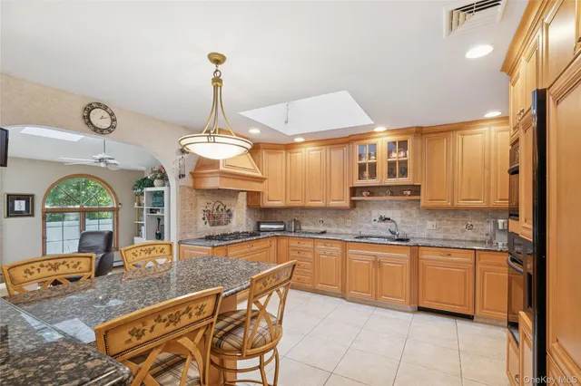 a kitchen with a stove a sink a dining table and chairs