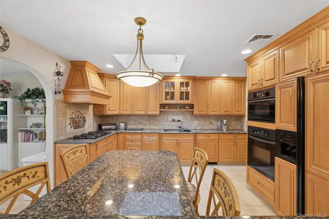 a kitchen with stainless steel appliances granite countertop a sink a stove and refrigerator